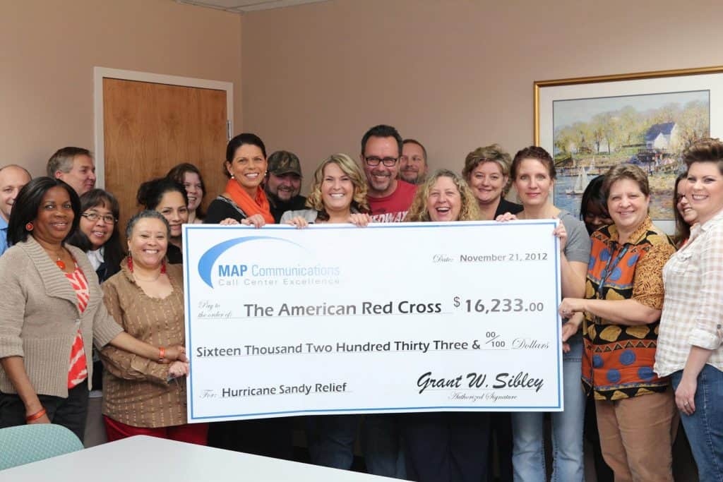 Image of people from MAP Communications presenting a large check to the American Red Cross.