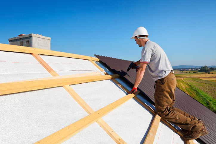 Image of a man installing a new roof who uses an answering service for roofers