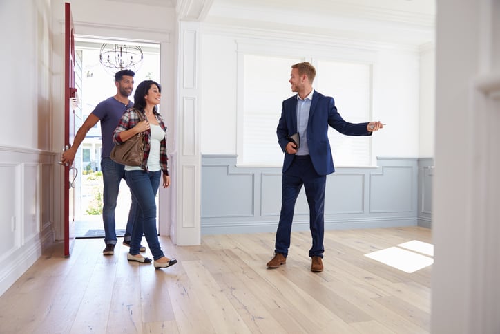 Image of a couple touring a home shown to them by an agent who uses a real estate answering service