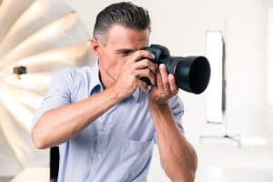 Image of a man taking a photo in is studio for his home-based business
