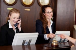 Image of front desk workers that use an answering service for hotels