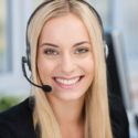 headshot of woman with blonde hair is wearing a call center headset and looking into the camera