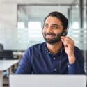 man wearing a call center headset and smiling on the job