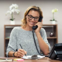 woman on the phone talking while in her small business office